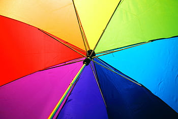 A close-up of a colorful rainbow umbrella showcasing vivid multicolored panels. HD wallpaper