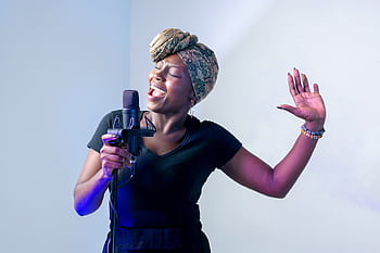 Passionate African woman singing in a music studio with a micro and headscarf. HD wallpaper