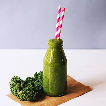Energizing green smoothie with kale, served in a bottle with vibrant straws for a healthy lifestyle. HD phone wallpaper