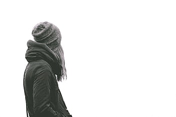 A woman in a winter jacket and beanie facing away on a plain background. HD wallpaper