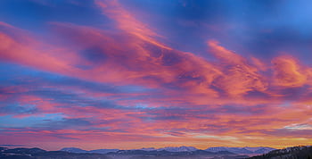 Stunning sunset with pink and orange hues over a mountainous horizon. HD wallpaper
