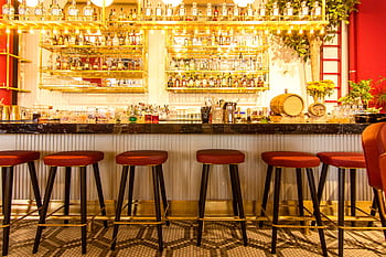 Sophisticated bar setup in Istanbul featuring sleek stools and a vibrant atmosphere. HD wallpaper