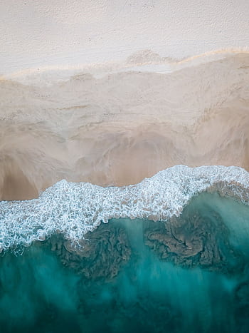 A stunning aerial view showcasing a sandy beach meeting the turquoise ocean waves. Perfect for travel and nature themes. HD phone wallpaper