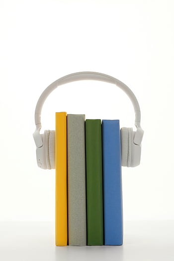 A stack of colorful books with heads, symbolizing audio learning on a white background. HD phone wallpaper