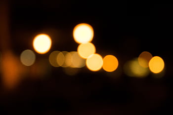 Blurred golden bokeh lights create a warm festive atmosphere on a dark background. HD wallpaper