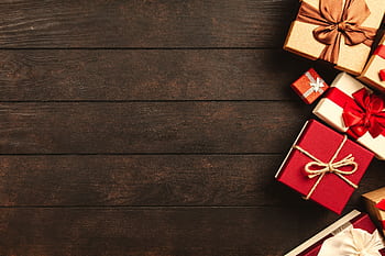 Decorative holiday gift boxes with ribbons on a rustic wooden surface, perfect for seasonal themes. HD wallpaper