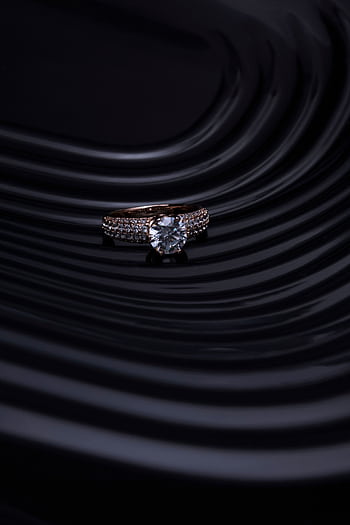 Close-up of a diamond ring with a dark, wavy background creating a luxurious and elegant atmosphere. HD phone wallpaper