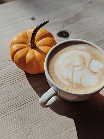 A latte with elegant art and a small pumpkin on a wooden table, capturing the essence of autumn. HD phone wallpaper