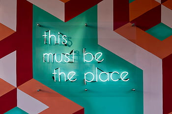 Colorful geometric wall featuring a glowing neon sign with an inspirational quote. HD wallpaper