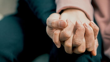 A close-up capturing two adult hands holding each other, symbolizing love and support. HD wallpaper
