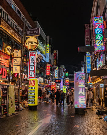 Bustling Seoul street scene with neon signs and people exploring Korea's vibrant nightlife. HD phone wallpaper