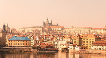 Prague Castle with historic buildings reflected in the Vltava River on a foggy day. HD wallpaper