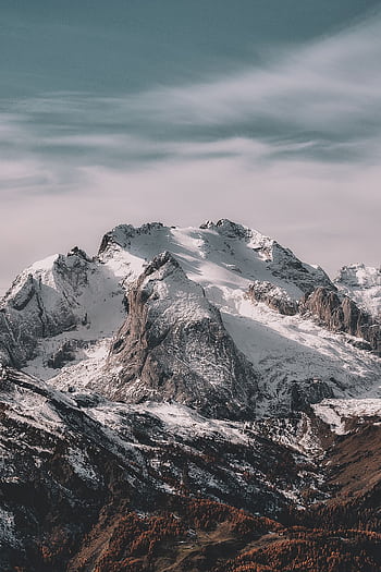 A breathtaking view of a snow-capped mountain range under a clear sky, capturing winter's beauty. HD phone wallpaper