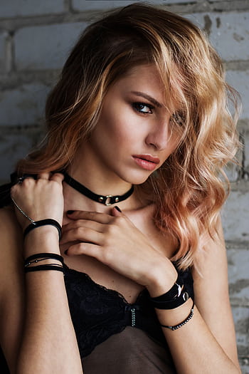 Close-up portrait of a stylish blonde woman in black lingerie against a brick wall. HD phone wallpaper