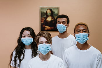 A diverse group wearing masks stands in front of a masked Mona Lisa painting. HD wallpaper