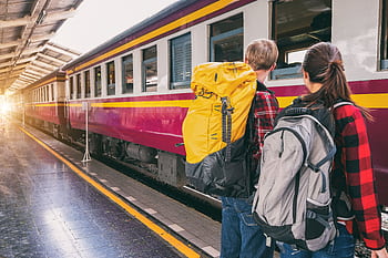 Backpackers waiting at a train station platform, ready for travel adventure. HD wallpaper