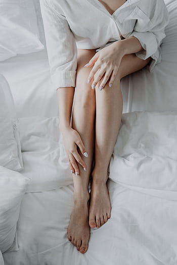An adult woman sitting in bed with white linen, showing relaxed and peaceful vibes. HD phone wallpaper
