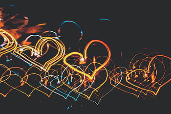 Vibrant heart shapes created with light painting in the dark. Perfect for creative and artistic themes. HD wallpaper