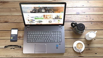 Top view of a laptop, smart, coffee, and glasses on a wooden desk. HD wallpaper
