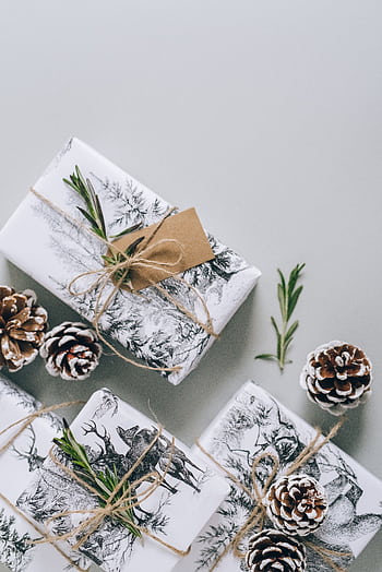 Aesthetic Christmas presents wrapped in twine with pinecones and greenery, perfect for the holiday season. HD phone wallpaper