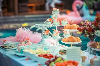 A beautifully arranged dessert table at an outdoor summer party near a pool. HD wallpaper