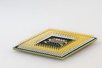 A detailed close-up of a CPU microchip showcasing its intricate gold pins and technology. HD wallpaper