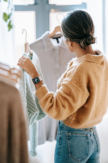 A woman shops for trendy clothes in a stylish boutique, showcasing fashion choices. HD phone wallpaper