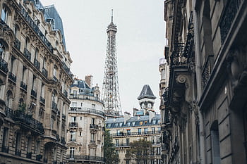 Scenic view of the Eiffel Tower framed by classic Parisian architecture on a charming street. HD wallpaper