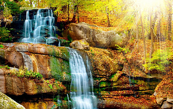 Waterfall lit by the autumn sun, rays, sunlight, glow, colors, nice, season, shine, cascades, autumn, fall, beautiful, rocks, park, stones, falling, leaves, waterfall, nature, lovely, forest, foliage HD wallpaper