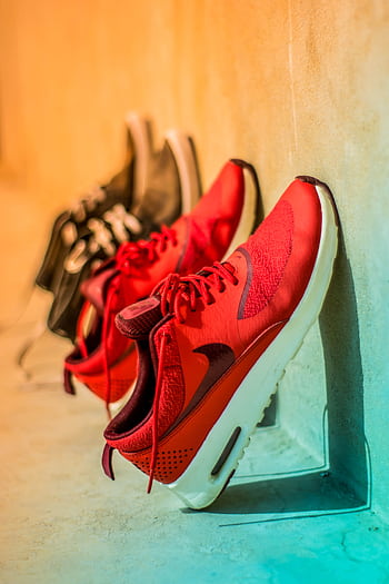 Vibrant red sneakers on display, showcasing modern footwear style. HD phone wallpaper