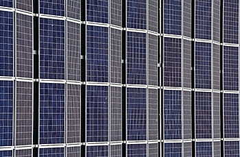 Close-up of multiple solar panels representing renewable energy and sustainability. HD wallpaper