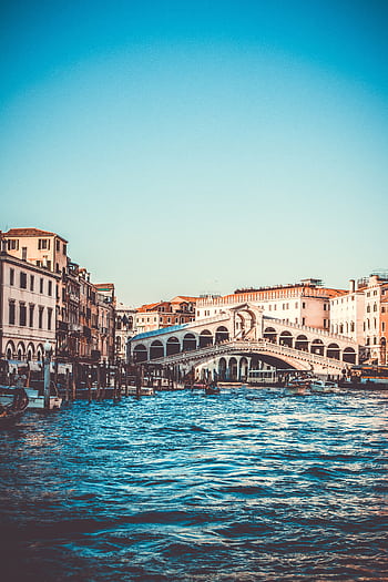 Explore the iconic Rialto Bridge over the Grand Canal in Venice, a must-visit tourist spot. HD phone wallpaper