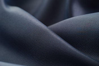 Elegant close-up of smooth, dark satin fabric showcasing texture and sheen. HD wallpaper