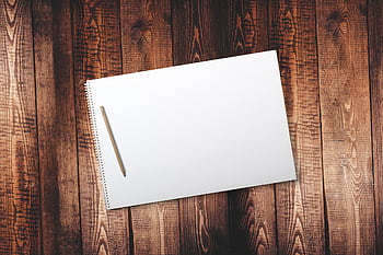 Open blank spiral notebook with pencil on wood table, perfect for creative or educational projects. HD wallpaper