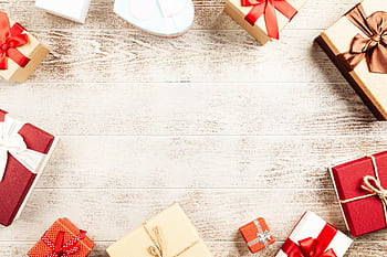 A top view of colorful gift boxes arranged on a rustic wooden table, perfect for holiday themes. HD wallpaper
