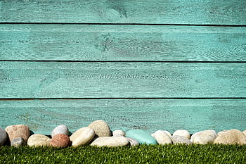 Turquoise wooden planks with pebbles and grass, perfect for a serene background. HD wallpaper