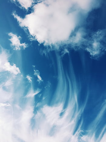 Serene cloud formations against a bright blue sky, capturing the beauty of daytime cloudscape. HD phone wallpaper