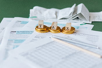 Close-up of tax forms, receipts, and coins symbolizing financial accounting and taxes. HD wallpaper