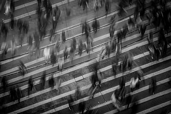 Blurred pedestrians crossing a busy Hong Kong street, showcasing urban movement and dynamics. HD wallpaper