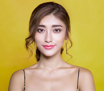 Beautiful portrait of a woman with elegant hairstyle on a vibrant yellow background. HD wallpaper