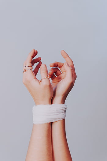 Close-up of delicate hands wrapped in gauze, symbolizing vulnerability and healing. HD phone wallpaper
