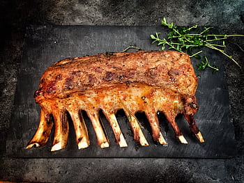 Delicious grilled spare ribs served with fresh herbs on a stone surface. HD wallpaper