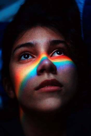 Portrait of a woman with a rainbow light across her face, capturing a moody and artistic feel. HD phone wallpaper