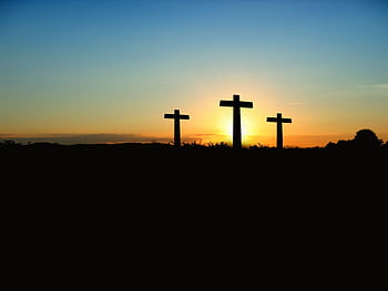 Silhouette of three crosses against a vibrant sunset sky. HD wallpaper