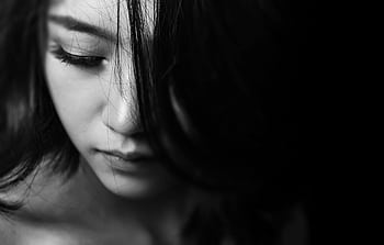 Monochrome close-up of a young woman with a thoughtful expression, emphasizing emotions. HD wallpaper