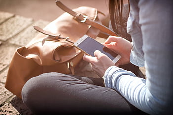 Woman sitting with smart and brown bag in sunlight. HD wallpaper