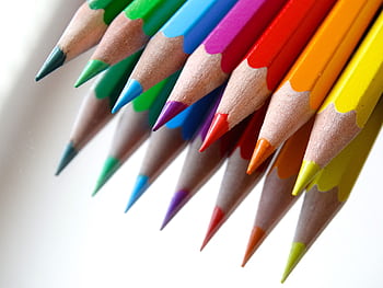 Vibrant colored pencils arranged on a white background, ideal for art and creativity. HD wallpaper