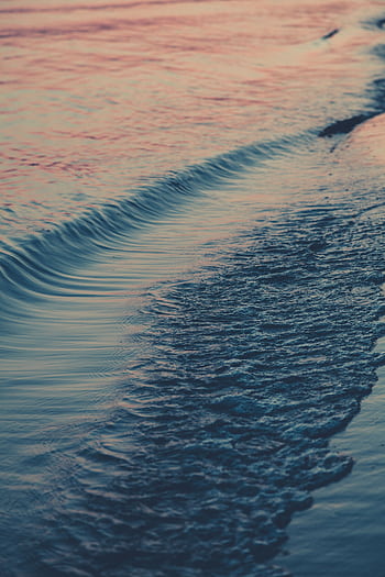 Serene ocean waves gently lapping the shore at sunset, creating a tranquil seascape. HD phone wallpaper