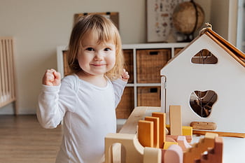 Adorable toddler joyfully playing with toys in a cozy indoor playroom, enjoying fun and happiness. HD wallpaper
