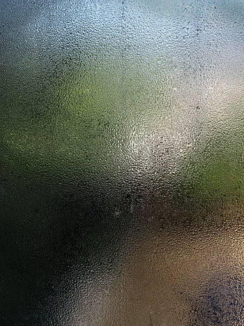 Close-up view of a wet glass pane with water droplets creating a blurred background effect. HD phone wallpaper